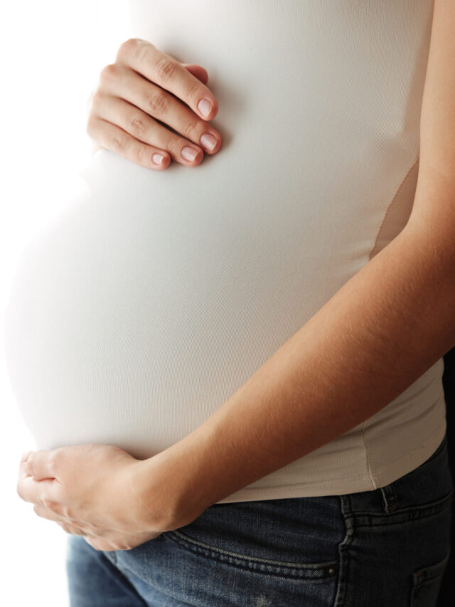 Close up portrait of a pregnant woman touching her belly